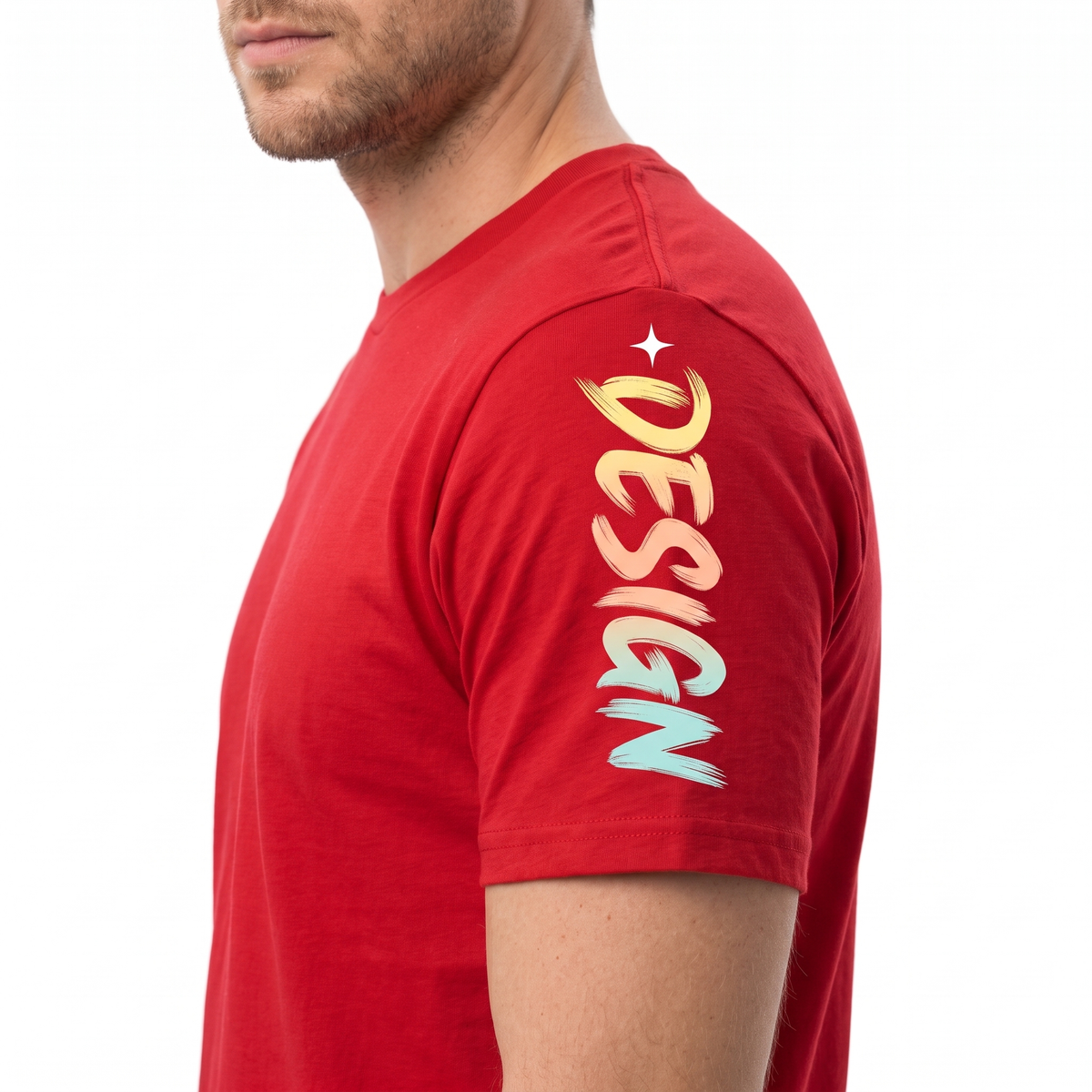 A man wearing a red short-sleeve t-shirt, shown from the side profile against a plain white background. The shirt features a colorful graphic on the upper left shoulder with the word 'DESIGN' in a vertical, brush-stroke style font transitioning through yellow, orange, and light blue, topped with a small white star.